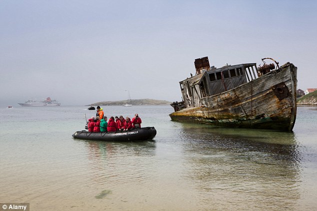 Cruise ship passengers are transported to shore by a zodiac boat, which is common from the larger ships