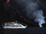 Eruption: A tourist boat watches on as lava from the Stromboli volcano flows into the Mediterranean Sea