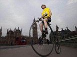 Look, no hands! Joff on his home-made penny farthing cycling along Westminster Bridge in London