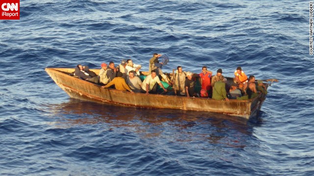 Passengers on a stranded boat signal for help from the Carnival Paradise on Tuesday in the Caribbean Sea.