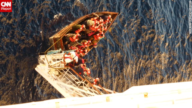 iReporter Matthew Sudder leaned over the railing of the Paradise to get this shot of the boat's passengers boarding the ship, wearing life jackets provided by the ship's crew. They were given water, food, clothing, accommodations and medical care.