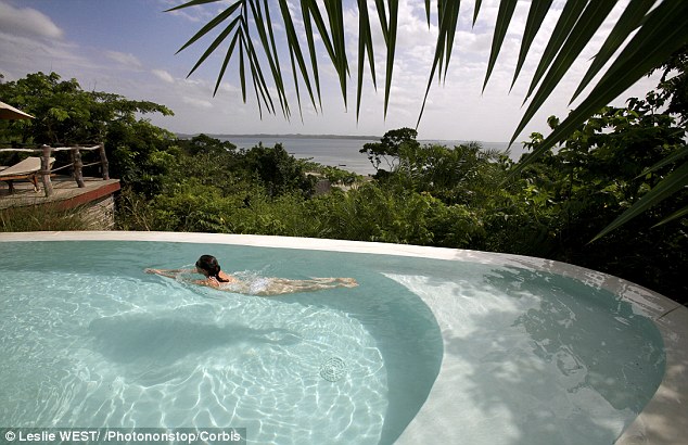 Crystal clear: A swimmer enjoys the Fundu Lagoon Hotel pool in Pemba, known as ¿the green isle¿