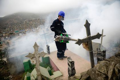 A specialist fumigates the Nueva Esperanza graveyard in the outskirts of Lima (ERNESTO BENAVIDES/AFP/Getty Images)