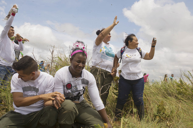 Rebels and family members wave as a helicopter transporting rebel leaders of the Revolutionary Armed Forces of Colombia, FARC, takes off from Yari Plains, Co...