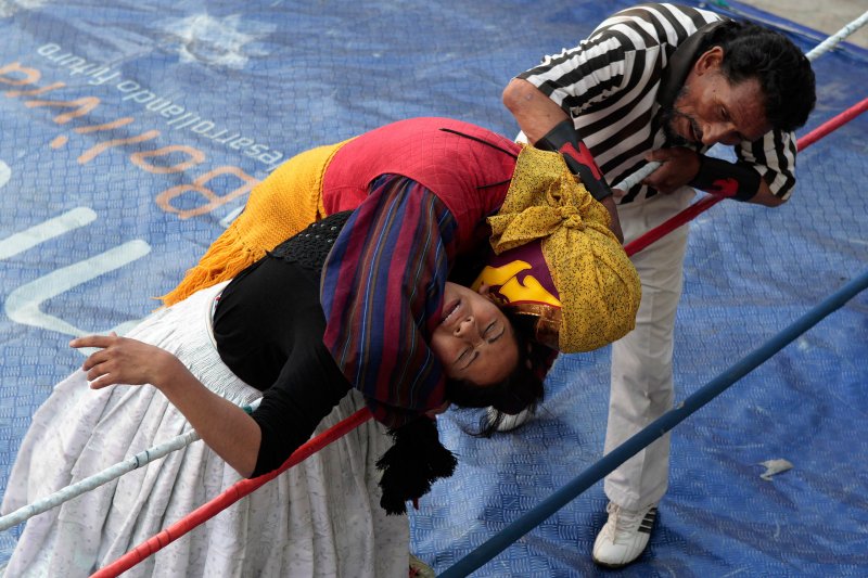 Bolivian Aymara Indian wrestler Benita (L), nicknamed The Untouchable, jumps at The Bucanero during a wrestling bout in a popular sports gym in La Paz, May 23, 2010. 