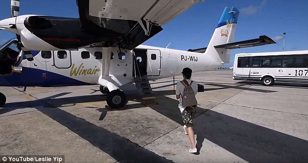 The hot pizza is taken across the tarmac and on to a waiting Winair plane