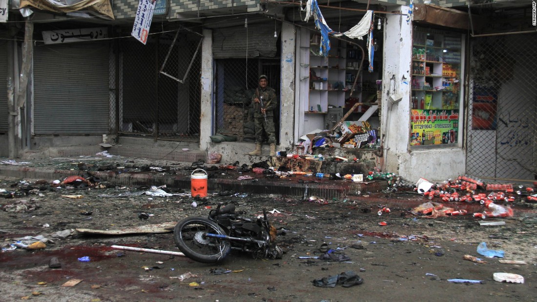 A member of Afghanistans security forces stands at the site where a suicide bomber on a motorbike blew himself up in front of the Kabul Bank in Jalalabad, Afghanistan, on Saturday, April 18. ISIS claimed responsibility for the attack. The explosion killed at least 33 people and injured more than 100 others, a public health spokesman said.