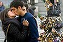A couple kiss near lamp posts covered with padlocks