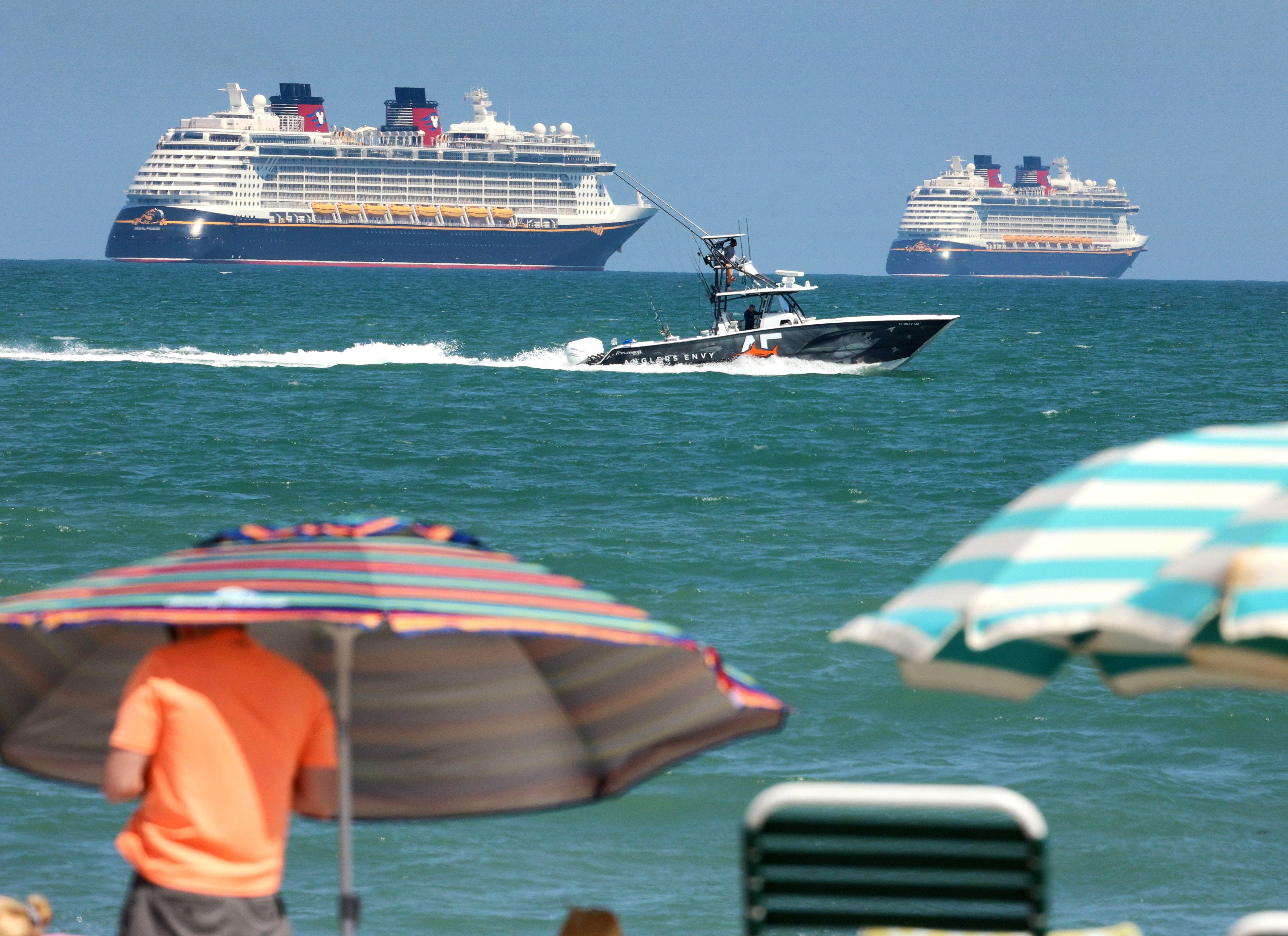 A sports fisherman passes the Disney Cruise Line ships on the horizon as they sit stationary off of Cocoa Beach, Florida in this view from Lori Wilson Park, March 24, 2021. Despite increasing pressure from the cruise industry and its allies in government, the U.S. Centers for Disease Control and Prevention plans to prevent cruises from U.S. ports for the foreseeable future.
