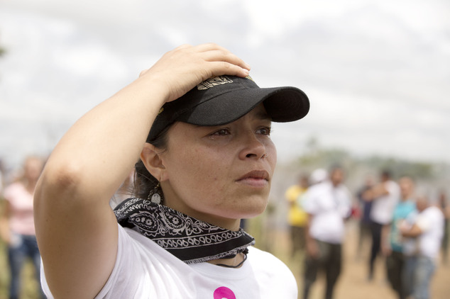 A rebel holds onto to her cap as a helicopter transporting leaders of the Revolutionary Armed Forces of Colombia, FARC, takes off from Yari Plains, Colombia,...