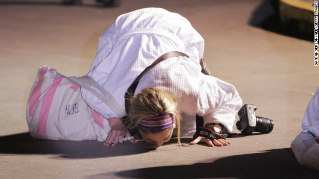 Passenger Kendall Jenkins kisses the ground after stepping off the Triumph.