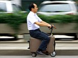 On yer bike: He Liangcai rides his electric suitcase vehicle home from work