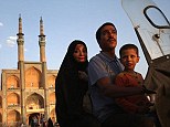 Ancient and modern: A family rides a motorcycle past the Amir Chakhmaq Hosseinieh worship site, one of the largest such structures in Iran, in Yazd