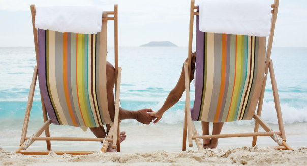 Couple on lounge chairs, holding hands (rear view), St. John, US Virgin Islands, USA