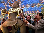 Warm welcome: Cambodia's Deputy Prime Minister Sok An (R) looks on as US diplomat Jeff Daigle (L) lays flowers at a ceremony for the return of 10th century statues in Phnom Penh