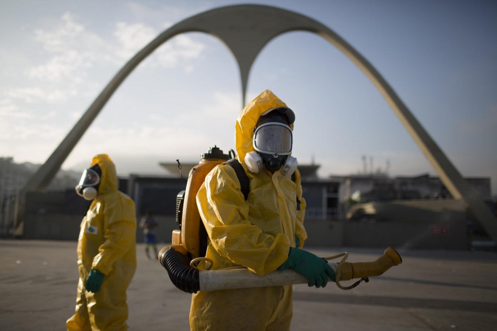 FILE - In this Tuesday, Jan. 26, 2016 file photo, a health workers stands in the Sambadrome spraying insecticide to combat the Aedes aegypti mosquito that transmits the Zika virus in Rio de Janeiro, Brazil. The Sambadrome will be used for the Archery competition during the 2016 summer games. With the opening ceremony less than three months away, a Canadian professor has called for the Rio Olympics to be postponed or moved because of the Zika outbreak, warning the influx of visitors to Brazil will result in the avoidable birth of malformed babies. The IOC and World Health Organization disagree, saying Zika will not derail the games.   (AP Photo/Leo Correa, File)