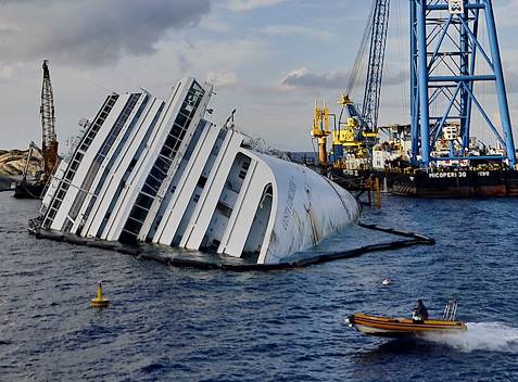 Image: The Costa Concordia cruise ship lays on its side near the harbor of Giglio, Italy, on Oct. 14, 2012