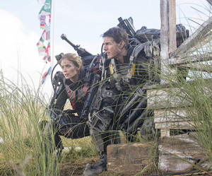 MAYBE THIS TIME WE WILL PREVAIL: William Cage (Tom Cruise, right) and Rita Vrataski (Emily Blunt) reconnoiter the landscape while trying to devise a strategy that will enable their army’s forces defeat the alien Mimics, who are trying to take over planet Earth. Fortunately, the pair have all the time they need, because each time William is killed, he immediately comes back to life and, together with Rita, the pair are given another chance to defeat the enemy.