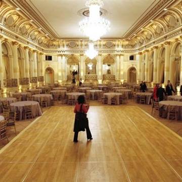 A journalist walks across the dance floor in the Grand Ballroom of The Plaza hotel as it re-opens in New York