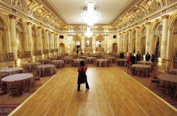 A journalist walks across the dance floor in the Grand Ballroom of The Plaza hotel as it re-opens in New York
