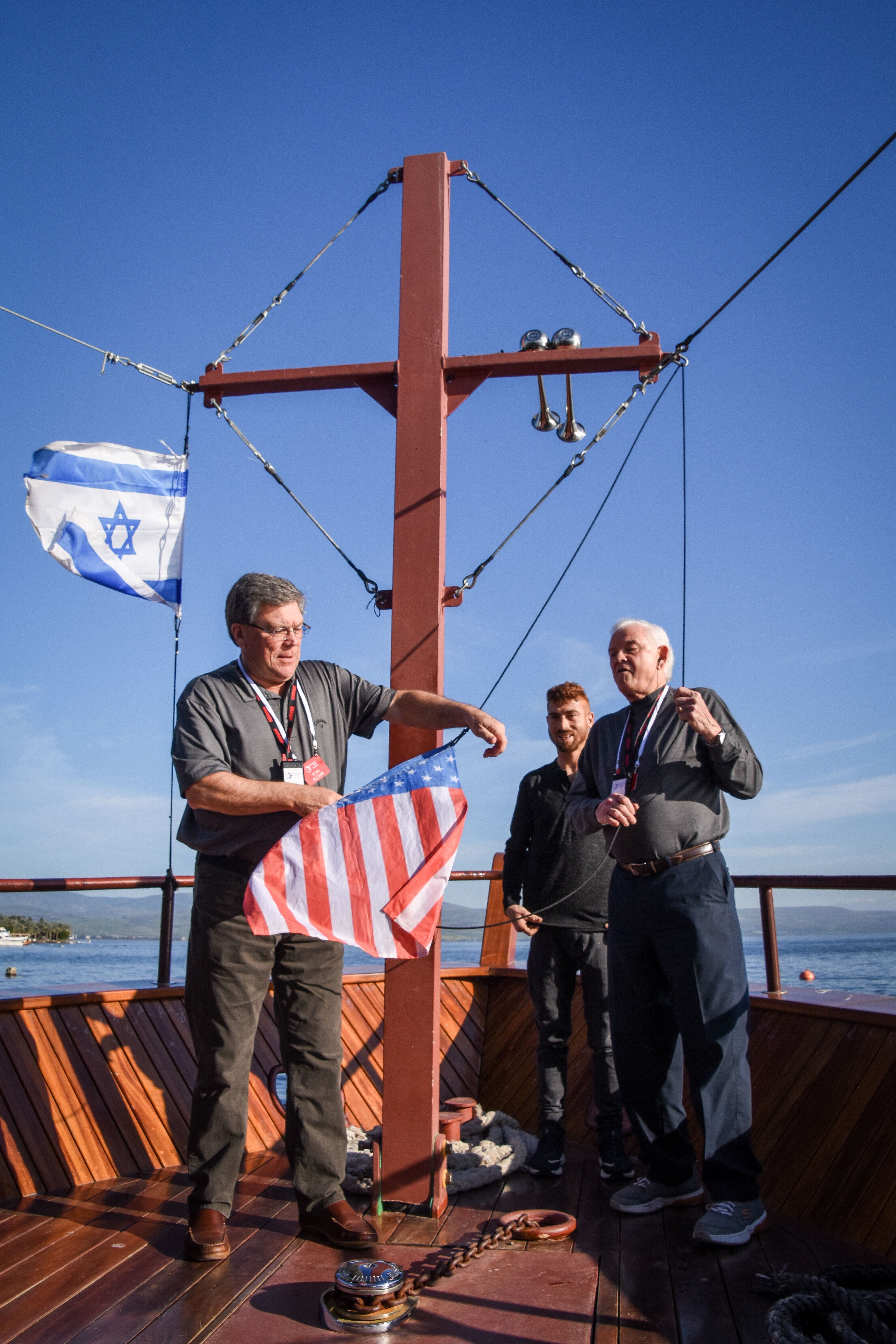 Stan Allcorn, left, and Russell Berry raise a U.S. flag on a boat on the Sea of Galilee in March 2020