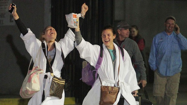 Friends cheer after stepping off  the crippled cruise liner in Alabama.