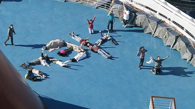 Passengers spell out the word HELP aboard the disabled Carnival Lines cruise ship Triumph as it is towed to harbour off Mobile Bay.