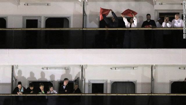 Passengers wave from the decks of the Triumph after docking at the Alabama Cruise Terminal in Mobile.