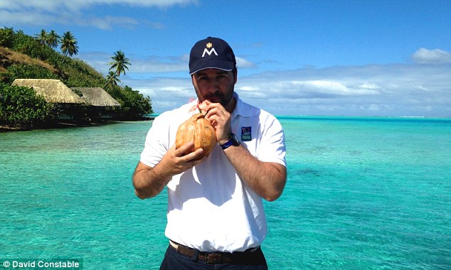 Coconut for one: David cools off with a tropical drink as he enjoys the delights of French Polynesia