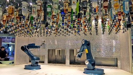 Bottles overhang the robot bartenders as they mix up tomorrows hangovers.