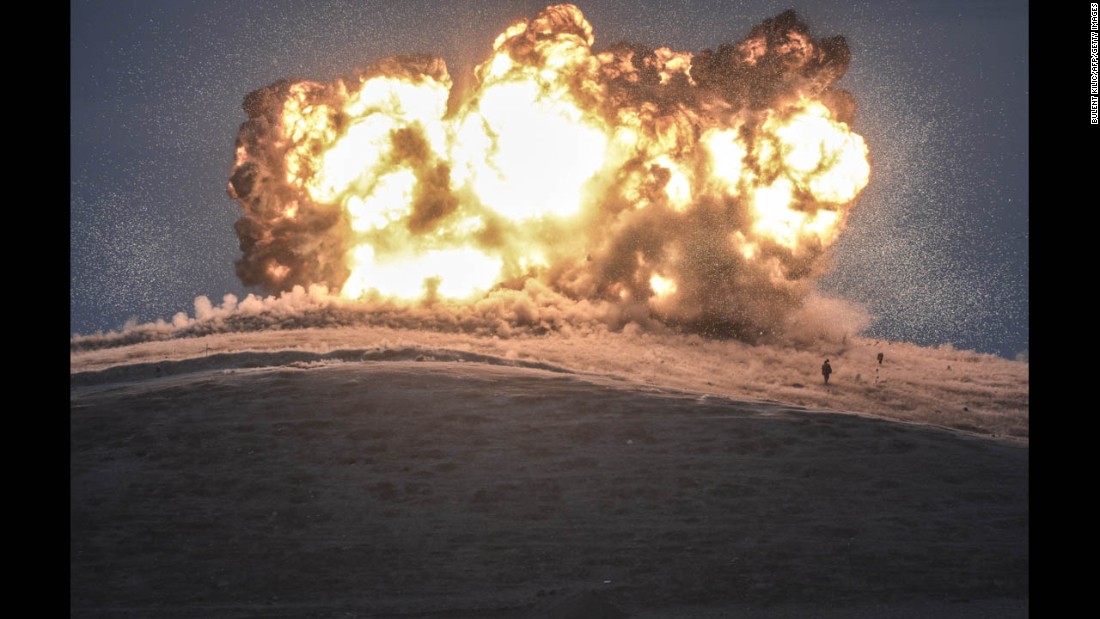 ISIS militants stand near the site of an airstrike near the Turkey-Syria border on Thursday, October 23. The United States and several Arab nations have been bombing ISIS targets in Syria to take out the militant groups ability to command, train and resupply its fighters.