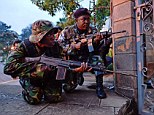 Attack: Kenyan security personnel take cover outside the Westgate Mall after shooting started inside the mall Saturday morning 