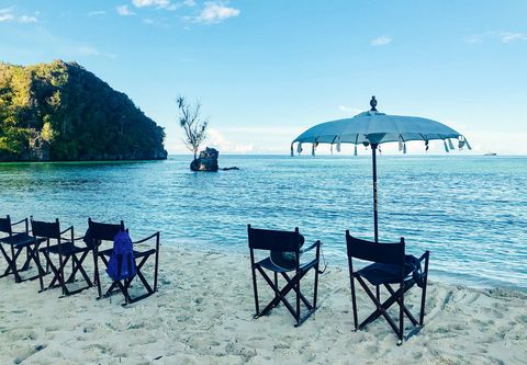 sundowners on the beach of a deserted island, raja ampat archipelago, indonesia