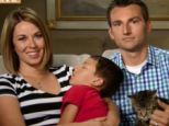 Safe: Erica and Roger Triantafilo sit with their sleeping four-year-old son Jeremy and Tara the cat, who saved him from a vicious dog attack outside their California home on Tuesday