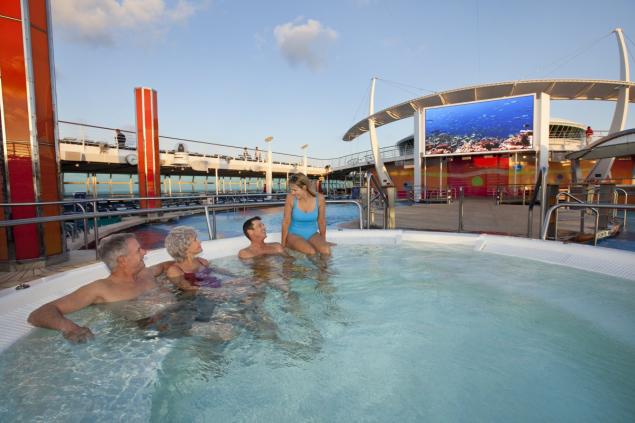 Those on board the Freedom of the Seas cruise ship can watch movies on an outdoor screen from the pool.