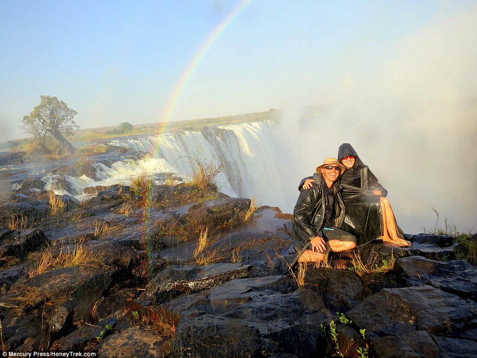 Over the rainbow: Nomadic couple Mike and Anne Howard pose at the iconic Victoria Falls, in Zambia